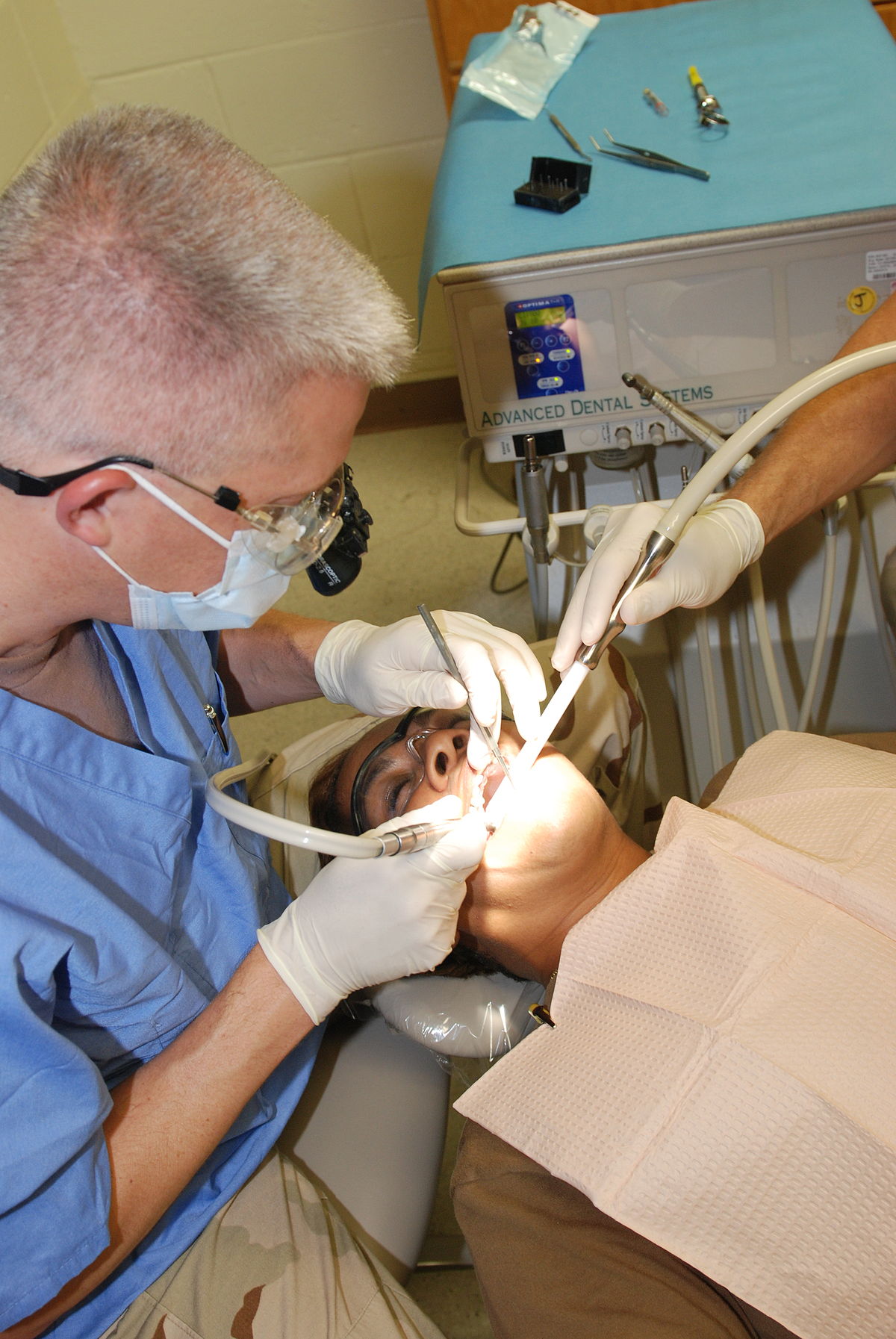 Dentiste traitant un patient avec l'aide d'une assistante dentaire